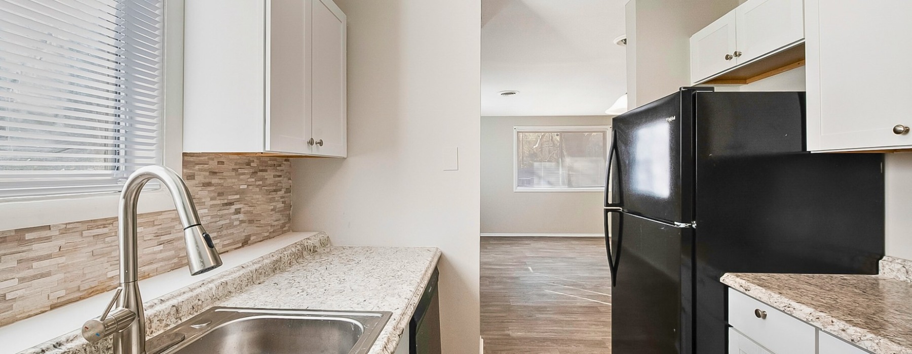 Bright galley kitchen looking into a dining room