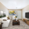 A living room witha white couch opposite a TV stand and coffee table